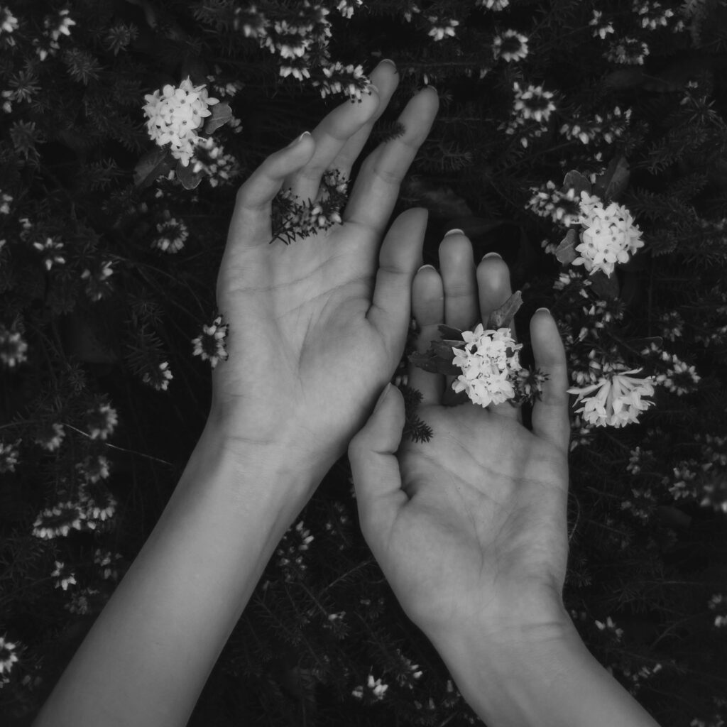 Deinen Körper lieben, bewusst wahrnehmen und dich glücklich fühlen. Zwei Hände die mit Blumen bestückt sind. Um Selbstliebe zu erleben und Ängsten und Depressionen gehen zu lassen. 