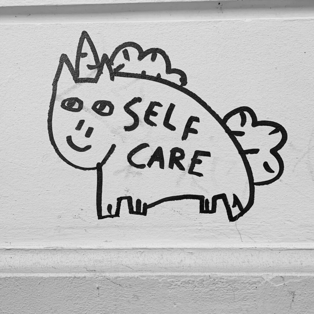 Sich Zeit für sich selbst nehmen. Auszeit, Ruhe und Entspannung für den Körper. Self Love Unicorn Grafiti, mit dem Spruch "Self Care" Berlin.