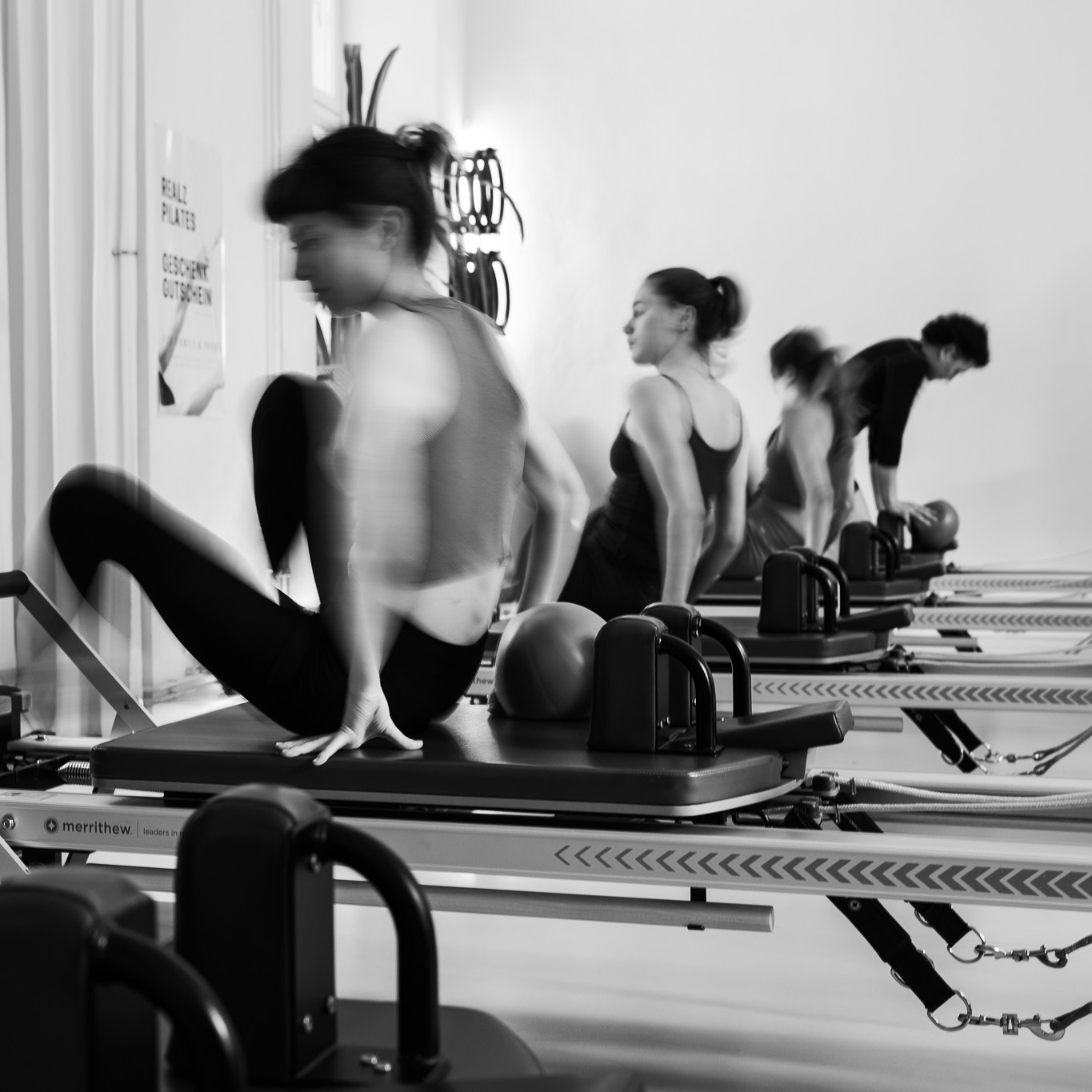 Pilates group in the Pilates studio, sitting on the Pilates reformer to start the Pilates class. Get yourself and your body moving. 