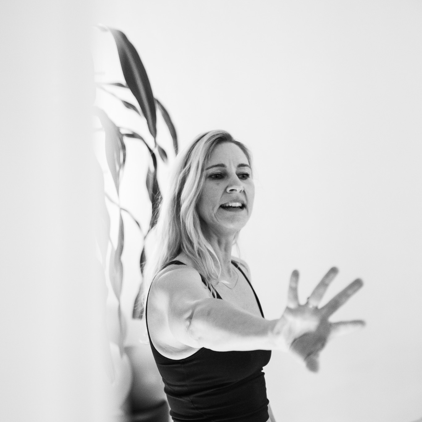 Eine Pilates Lehrerin im Unterricht, im Pilates Studio REALZ Pilates Berlin. Sie leitet taktile die Klasse an.