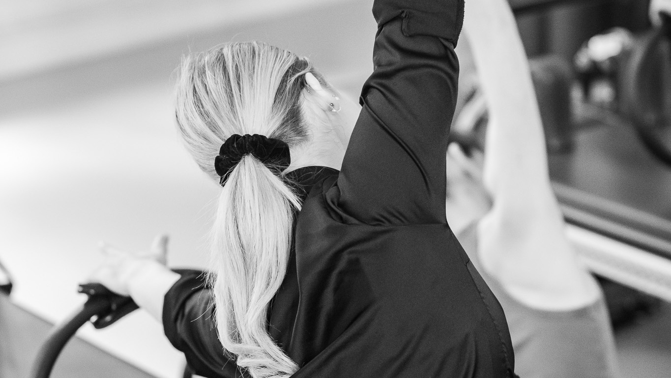 Two young women stretch sideways with the Magic Circle, enjoying the lateral stretch to connect with their bodies.