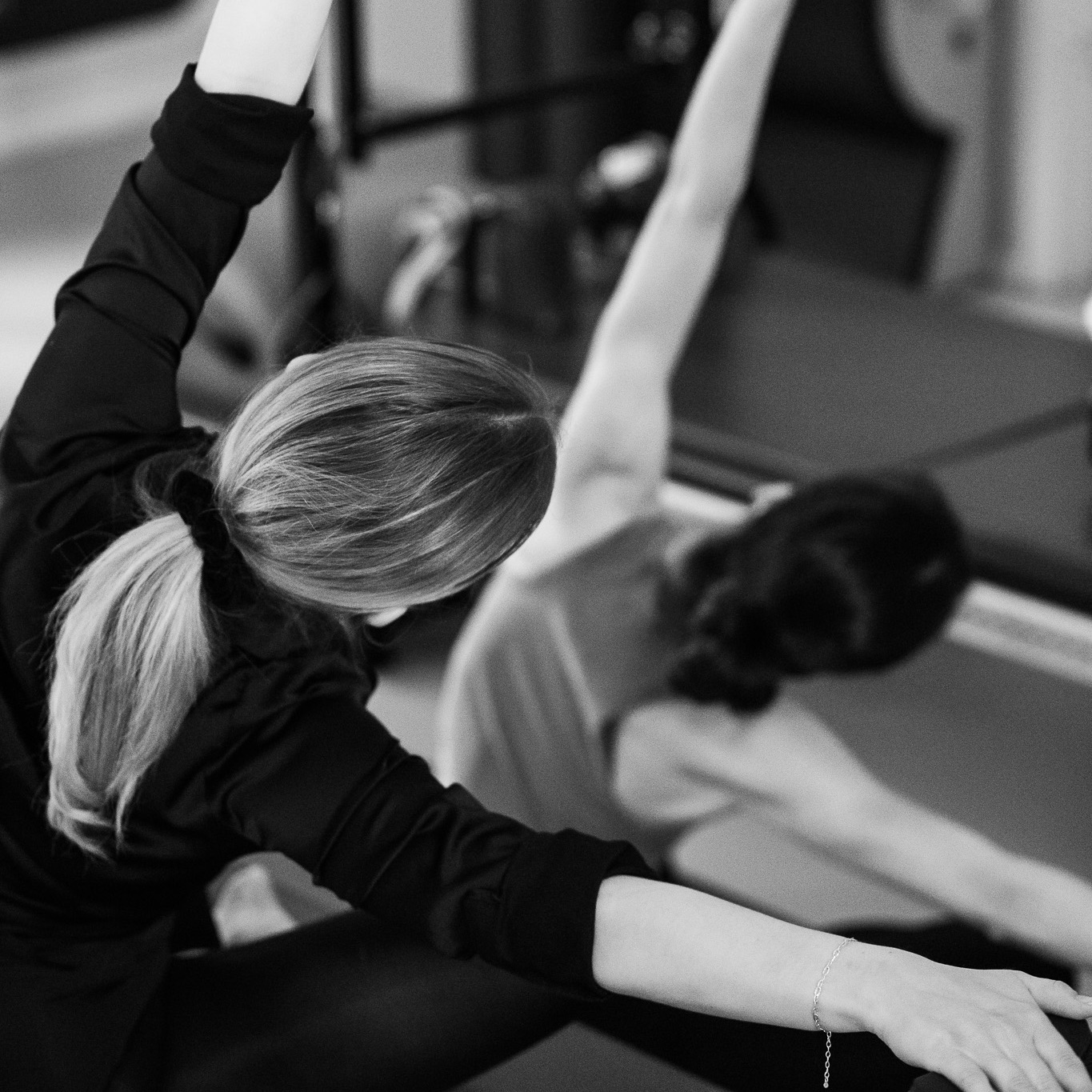Mobilisations- und Dehnungsübungen im Pilates Duo Training. Zwei. junge Frauen trainieren gemeinsam und genießen den Side-Bend Stretch mit dem Magic Circle.