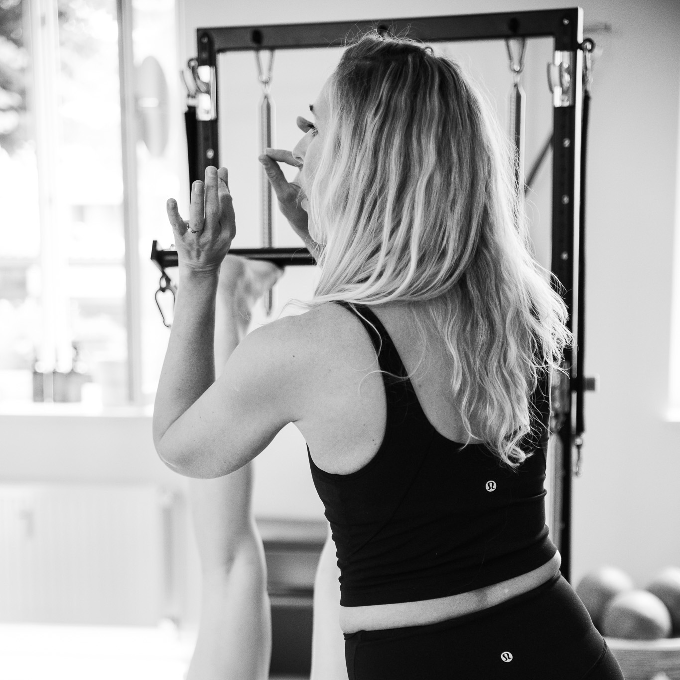 A Pilates instructor teaches in small groups with exceptional quality, providing precise instruction and personalized guidance for every participant training on the Pilates equipment. Small Groups, Exceptional Quality.